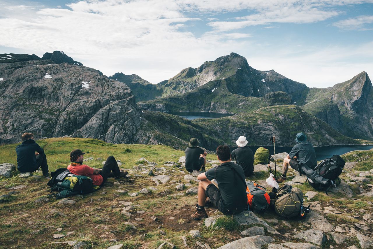 Photo taken at Norway, Lofoten, Moskenesoy with hikers taking a break, looking at the mountains.