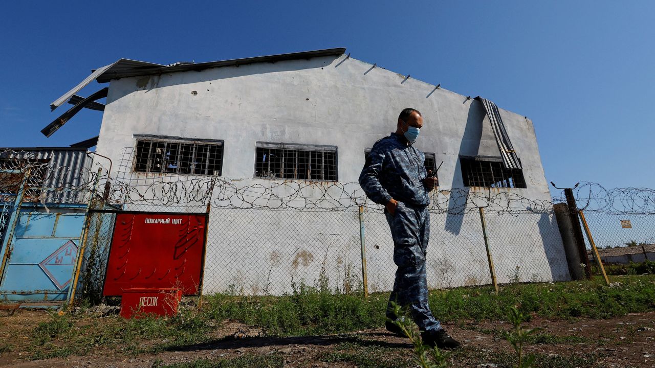 A security guard stands in front of the building in the settlement of Olenivka in the Donetsk Region, Ukraine August 10, 2022, in this picture taken during a media tour organised by the Russian Defence Ministry. 