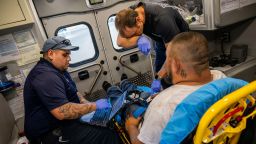 Emergency Medical Technicians William Dorsey and Omar Amezcua assist a person after he called in for chest pain on June 29, 2023 in Eagle Pass, Texas.