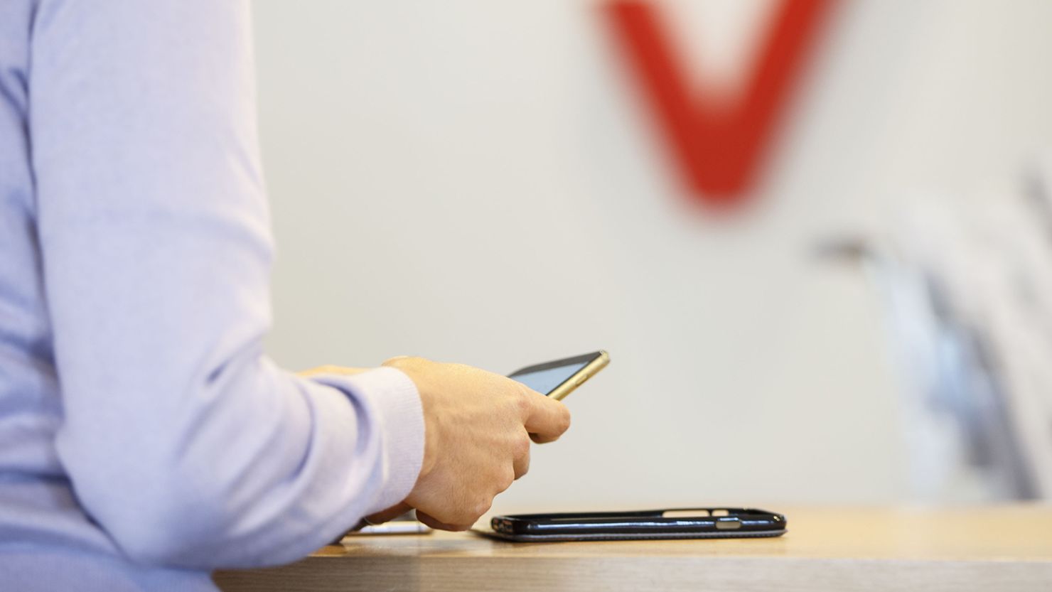 A customer uses an Apple Inc. iPhone smartphone at a Verizon Communications Inc. store in Brea, California, U.S., on Monday, Jan. 22, 2018.