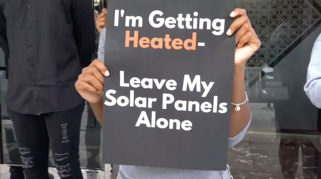 People hold signs during a mock protest organized by Imani Wj Wright. A report by Mandiant suggests a pro-Beijing group that contacted Wright distributed footage from this mock protest on social media depicting the demonstration as real. 