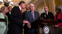 WASHINGTON, DC - JULY 26: (L-R) Sen. John Barrasso (R-WY) reaches out to help Senate Minority Leader Mitch McConnell (R-KY) after McConnell froze and stopped talking at the microphone during a news conference after a lunch meeting with Senate Republicans U.S. Capitol 26, 2023 in Washington, DC. Also pictured, L-R, Sen. Shelley Moore Capito (R-WV), Sen. Steve Daines (R-MT), Sen. John Thune (R-SD) and Sen. Joni Ernst (R-IA). McConnell was escorted back to his office and later returned to the news conference and answered questions.  (Photo by Drew Angerer/Getty Images)