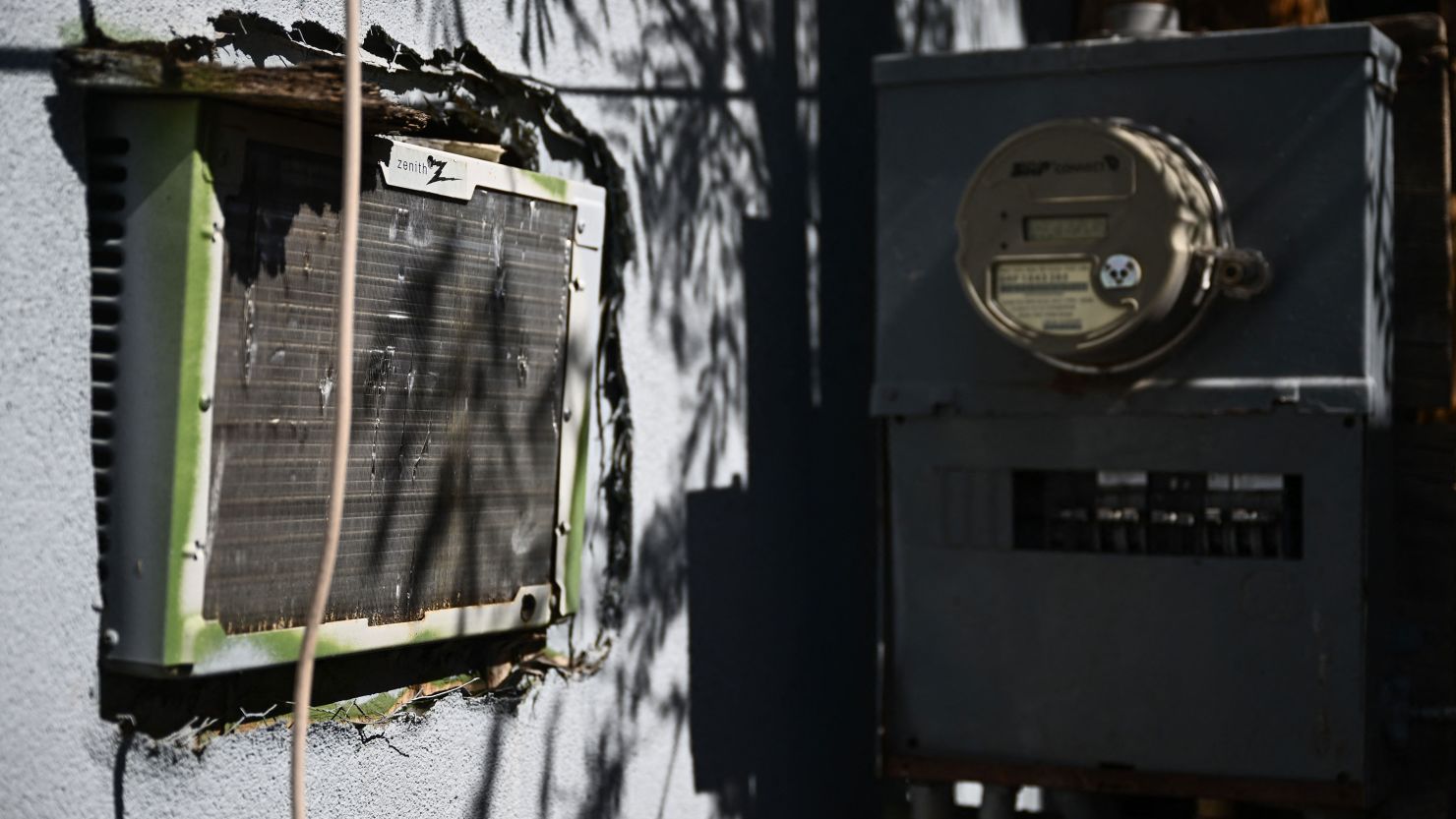 A window mounted air conditioning unit hangs through a wall of a mobile home next to an electrical panel during a record heat wave in Phoenix, Arizona on July 20, 2023. A study in 2022 by Arizona State University found that while mobile homes make up just five percent of all housing in metropolitan Phoenix, they account for 30% of heat-related deaths in the city. (Photo by Patrick T. Fallon / AFP) (Photo by PATRICK T. FALLON/AFP via Getty Images)