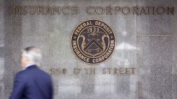 A pedestrian walks outside the headquarters of the U.S. Federal Deposit Insurance Corp., on Wednesday, May 27, 2009. 