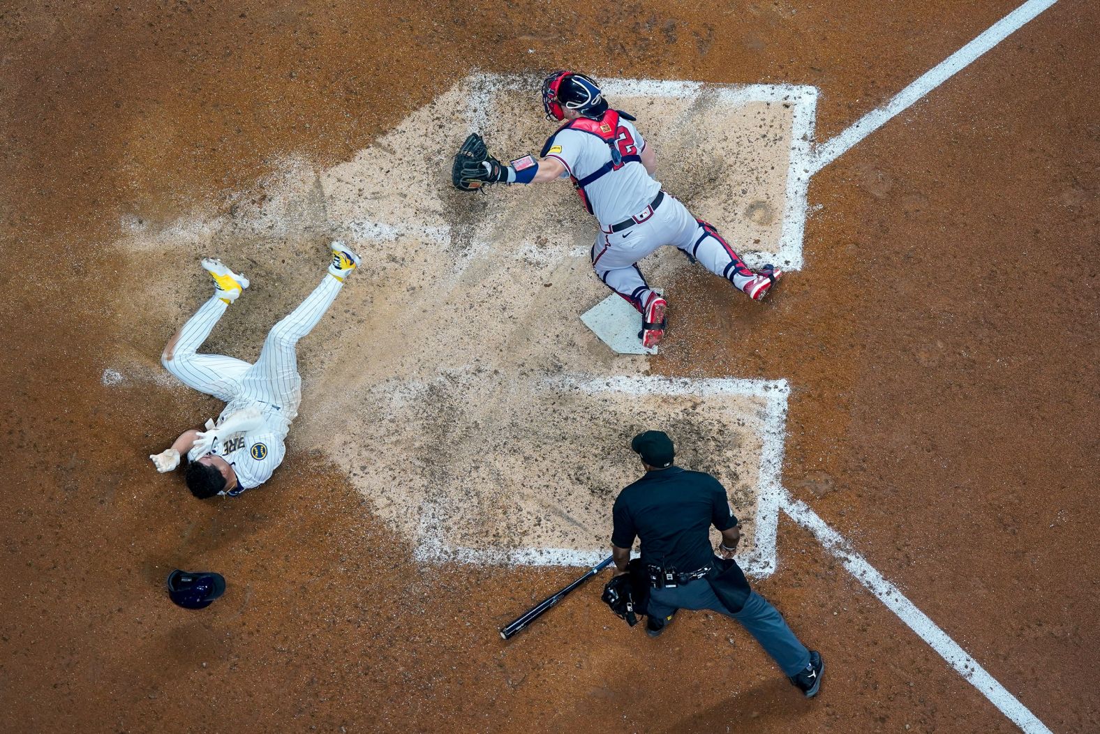 The Milwaukee Brewers' Willy Adames, left, slides past Atlanta Braves catcher Sean Murphy after scoring a run during a Major League Baseball game in Milwaukee on Saturday, July 22. The run, which came on a sacrifice fly by Sal Frelick, lifted the Brewers to a 4-3 victory.