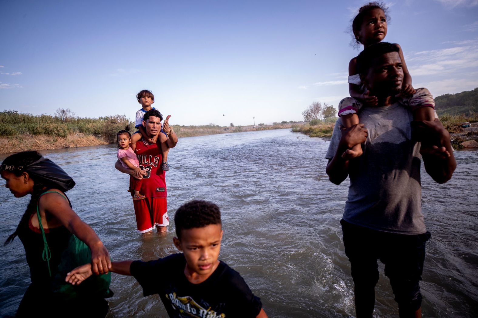 Migrants cross the Rio Grande from Mexico into the United States on Thursday, July 20. They were part of a group of nearly 30 people who crossed into Eagle Pass, Texas, to seek asylum.
