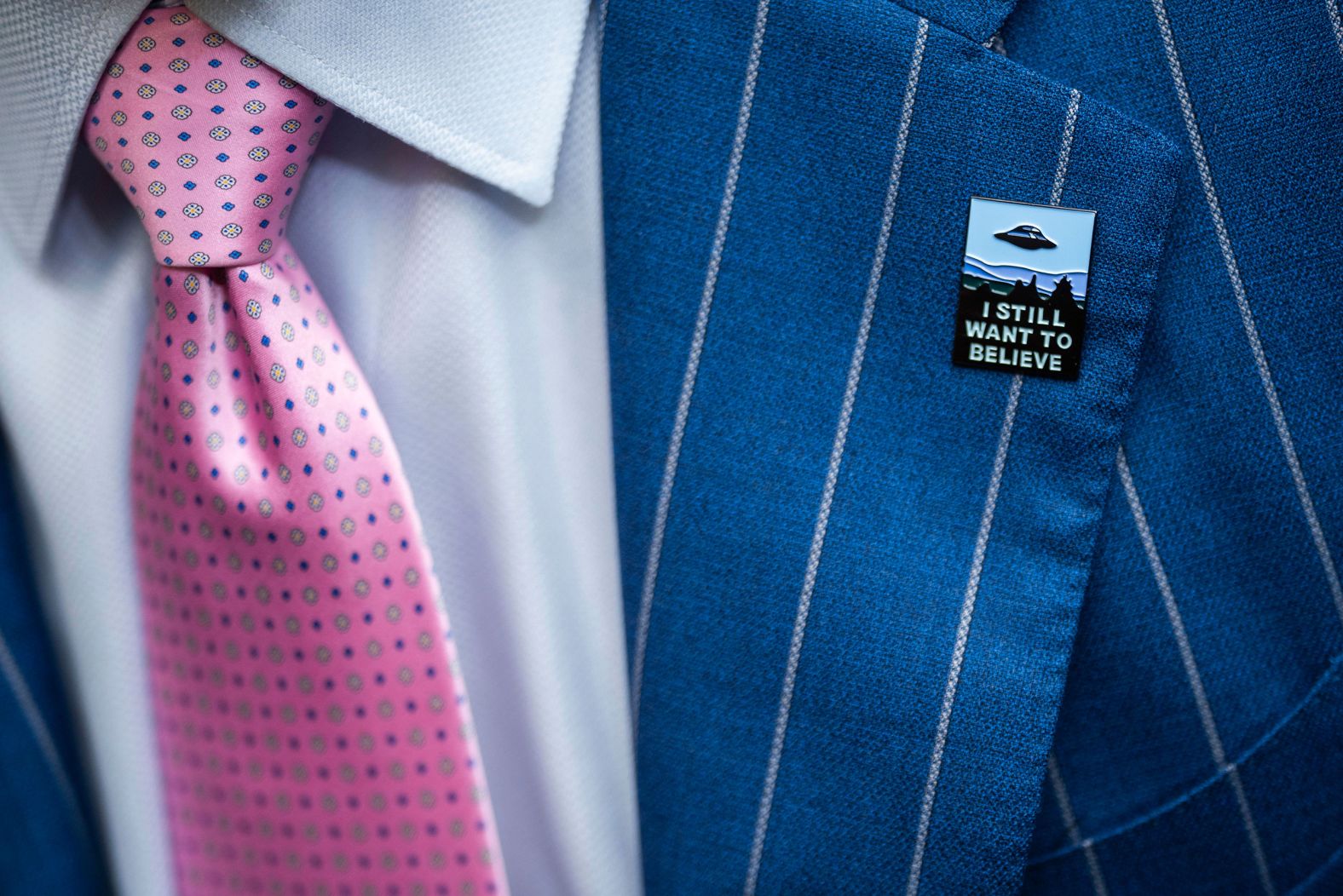 An audience member wears a "I Still Want to Believe" pin in Washington, DC, while attending a <a href="https://www.cnn.com/2023/07/26/politics/ufo-house-hearing-congress/index.html" target="_blank">House hearing on unidentified anomalous phenomena</a> — commonly known as UFOs — on Wednesday, July 26. Three retired military veterans testified at the hearing, warning that UFO sightings are a national security problem and that the government has been too secretive about them.