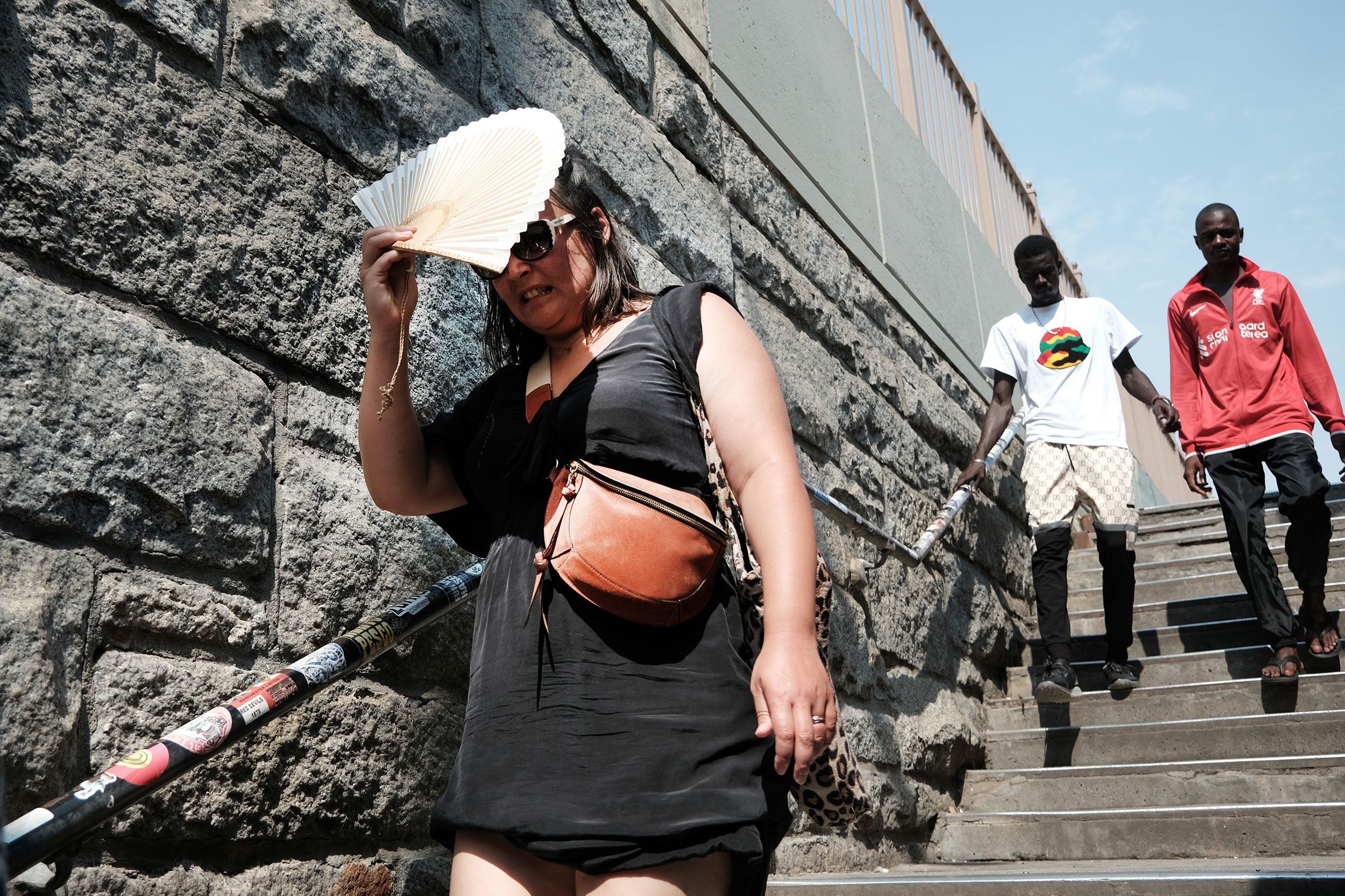 A woman shades herself from the sun along the Brooklyn Bridge in New York on July 27.