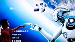 BEIJING, CHINA - AUGUST 18: A boy points to the AI robot Poster during the 2022 World Robot Conference at Beijing Etrong International Exhibition on August 18, 2022 in Beijing, China. The 2022 World Robot Conference kicked off on Thursday in Beijing. (Photo by Lintao Zhang/Getty Images)