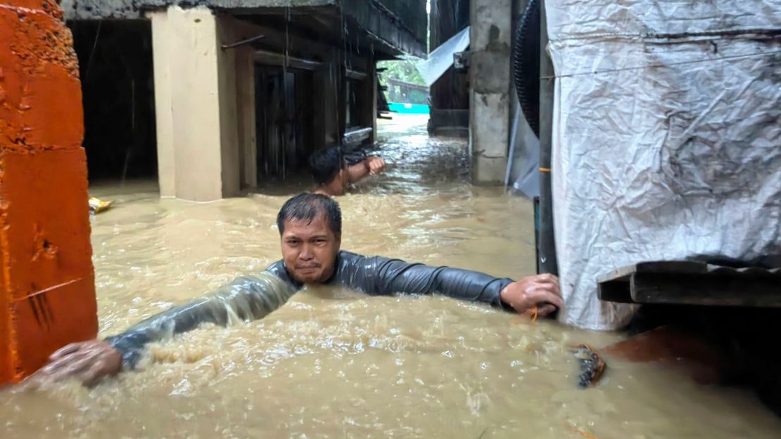 A man negotiates neck-deep floodwaters in Laoag city, Ilocos Norte province, northern Philippines.