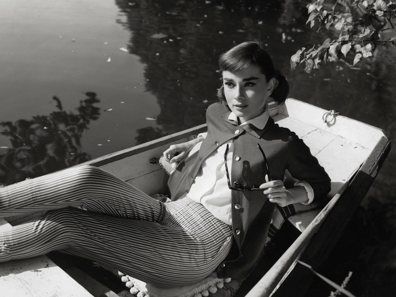 Effortlessly chic, Audrey Hepburn is pictured in the movie "Love in the Afternoon," wearing a pair of fitted plaid capri pants, a light cardigan and crisp white button-down shirt.