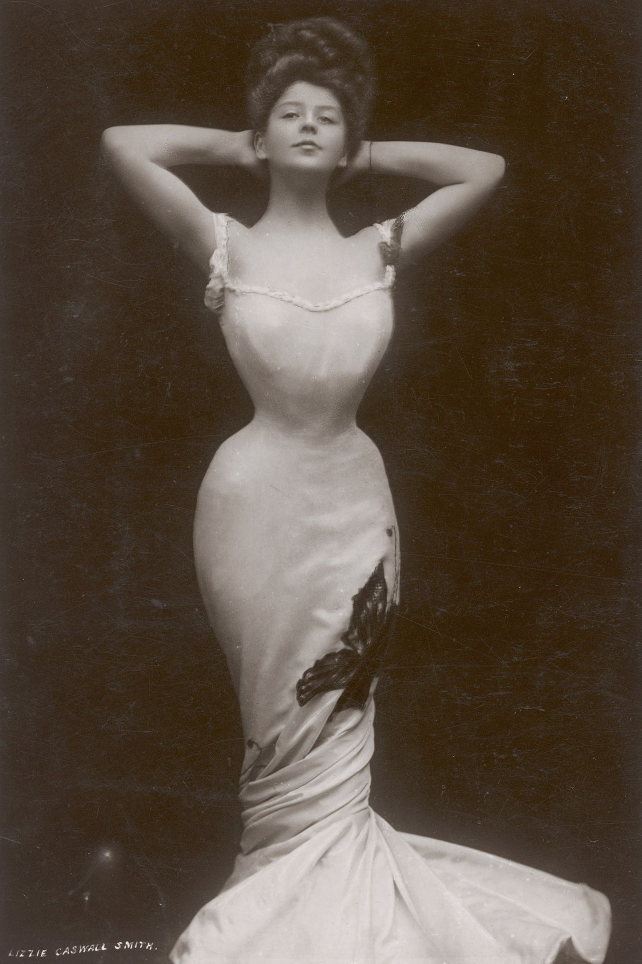 Actress Camille Clifford poses in a circa-1906 photo, wearing a white fishtail gown with a tightly-cinched waist.