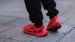 A fashion week guest seen wearing red Adidas Yeezy shoes during London Fashion Week in September 2022.