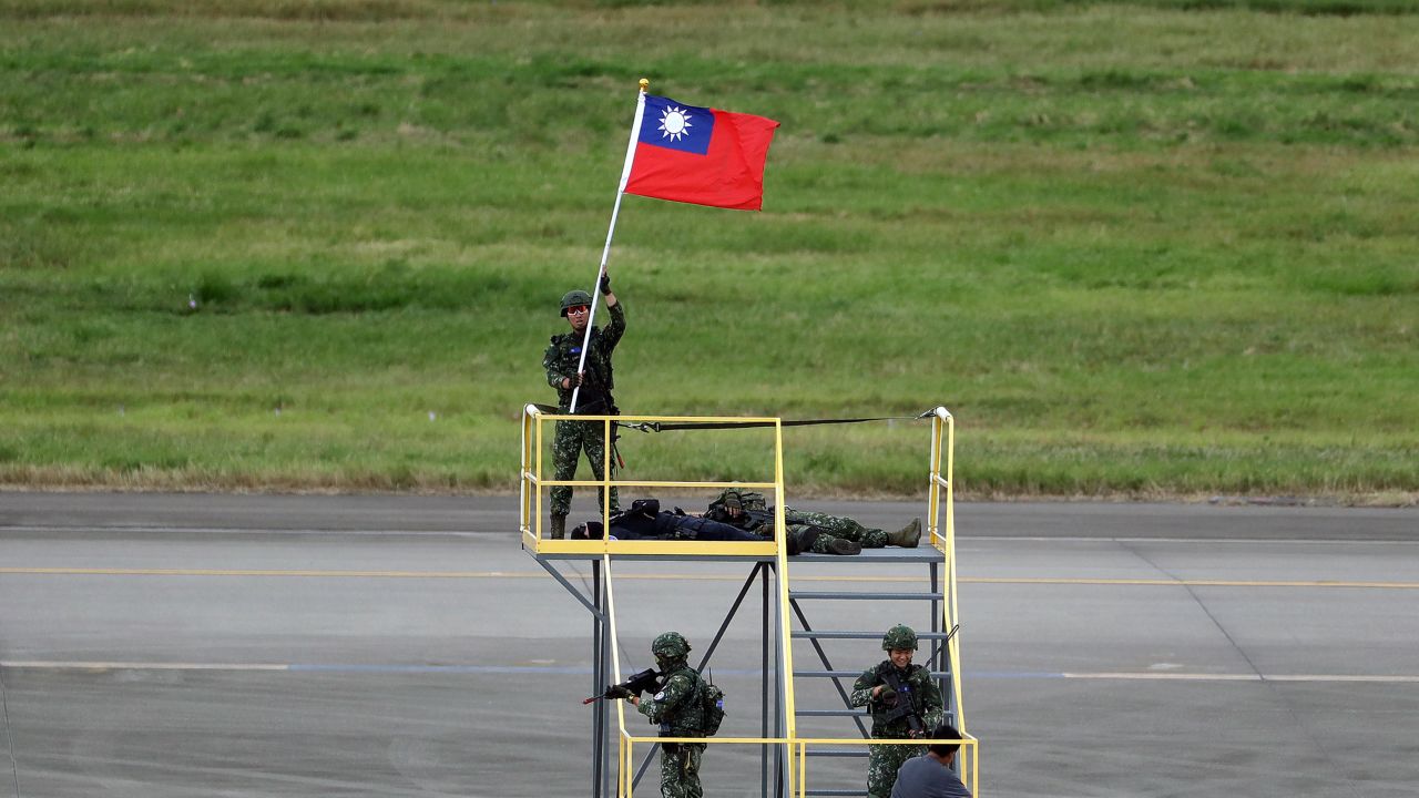 In this July 26 photo, a soldier holds a Taiwan national flag during the annual Han Kuang military exercises that simulate an attack on an airfield at Taoyuan International Airport in Taoyuan, northern Taiwan.