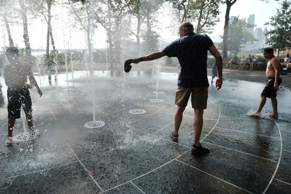 People keep cool in a fountain at New York's Battery Park on Thursday, July 27.