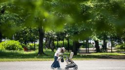 A woman walks with her child at a park in Tokyo on May 11, 2023. 