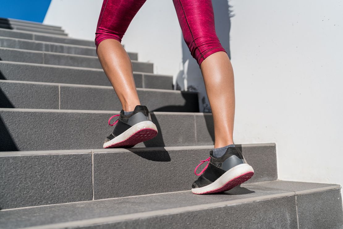 Cầu thang leo lên, người phụ nữ đang chạy, chạy lên bậc thang trên cầu thang. Nữ vận động viên chạy bộ đi lên cầu thang ở thành phố thành phố tập luyện thể thao tim mạch chạy bên ngoài vào mùa hè. Quần legging và giày năng động.