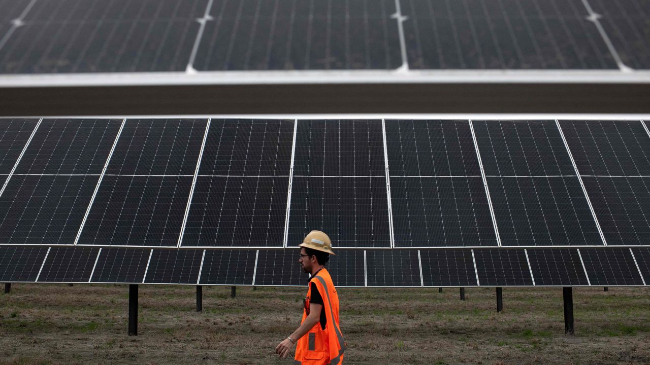 An ENGIE employee walks past solar panels at the ENGIE Sun Valley Solar project in Hill County, Texas.