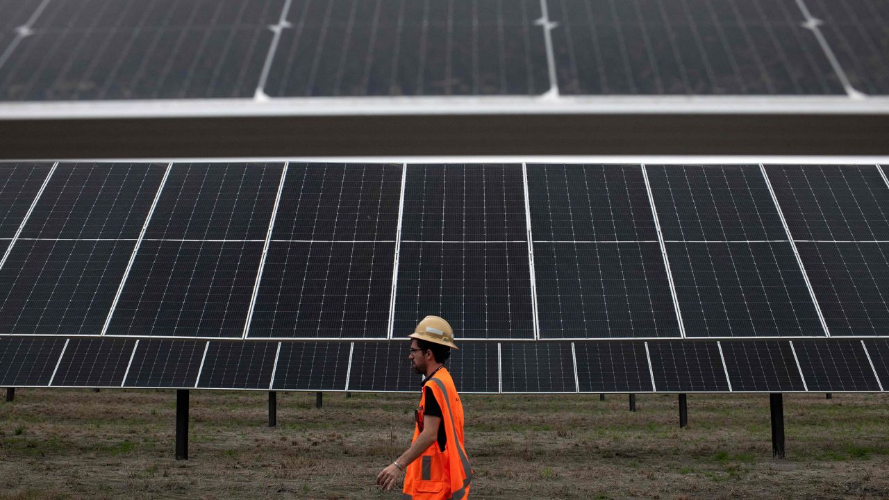 Служител на ENGIE минава покрай слънчеви панели в проекта ENGIE Sun Valley Solar в окръг Хил, Тексас.