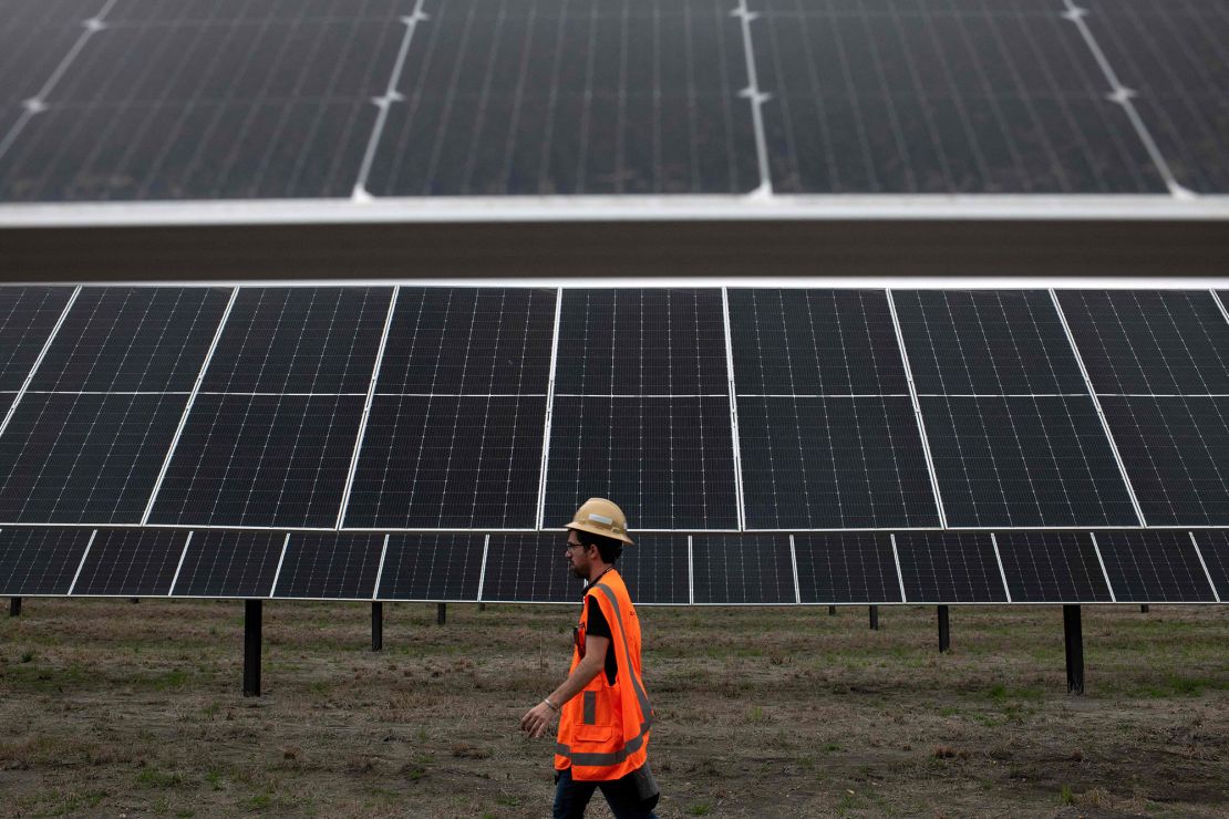 An ENGIE employee walks past solar panels at the ENGIE Sun Valley Solar project in Hill County, Texas.