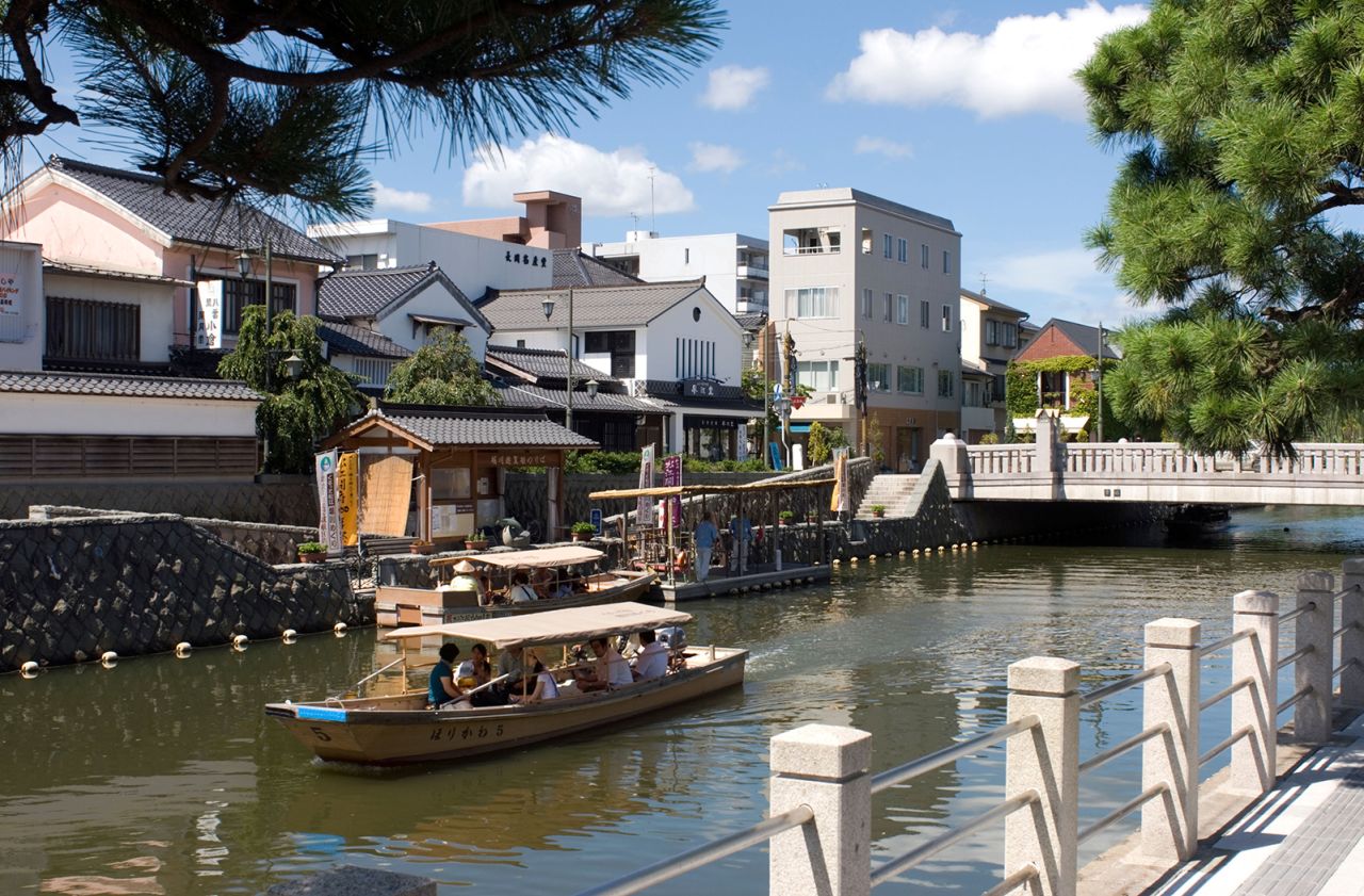 B2KT87 On a sunny day tourists ride a boat through the canals of the city of Matsue in Shimane Prefecture