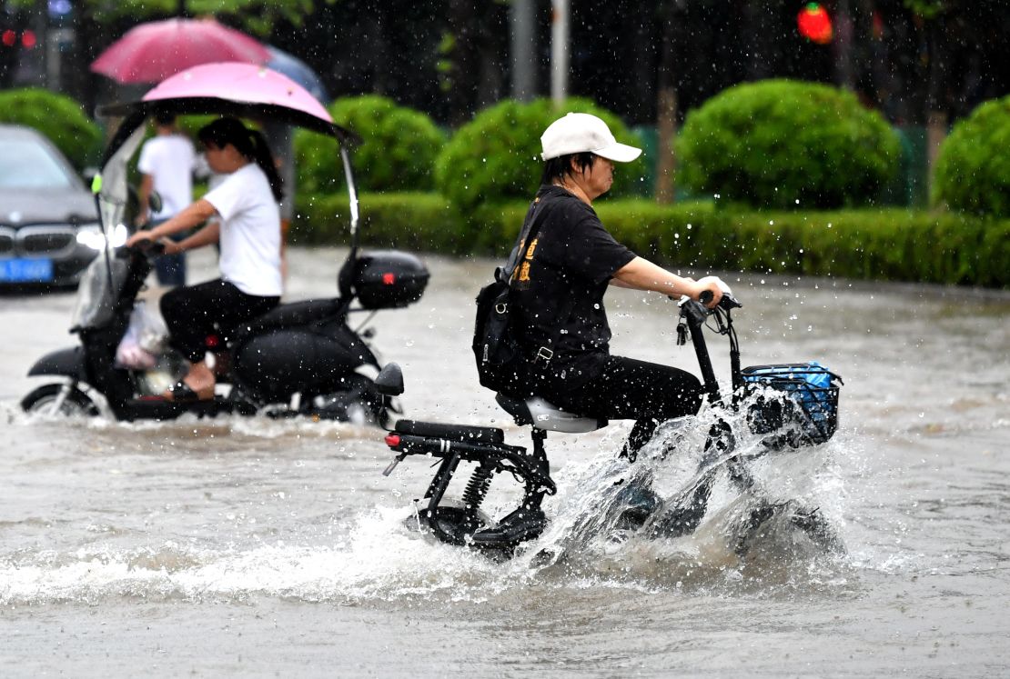 Cyclists ride along a flooded street in Fuzhou.