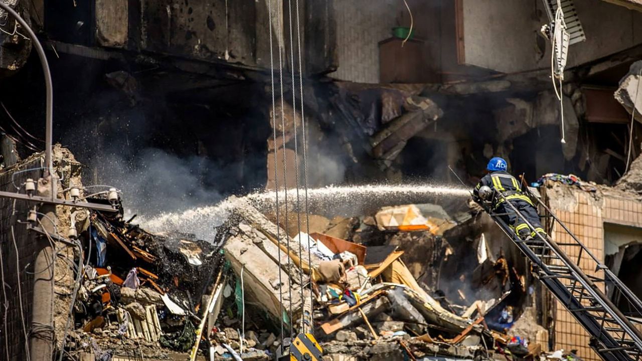 A firefighter is seen working on one of the damaged buildings on Monday.