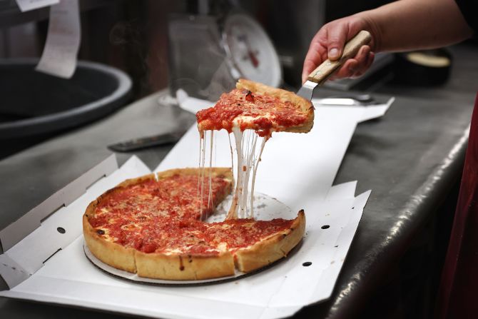 <strong>Chicago deep dish pizza:</strong> A worker prepares a Chicago-style deep dish pizza at a Lou Malnati's restaurant in Chicago. A marker of this style is dough pressed up along the sides of the pan.