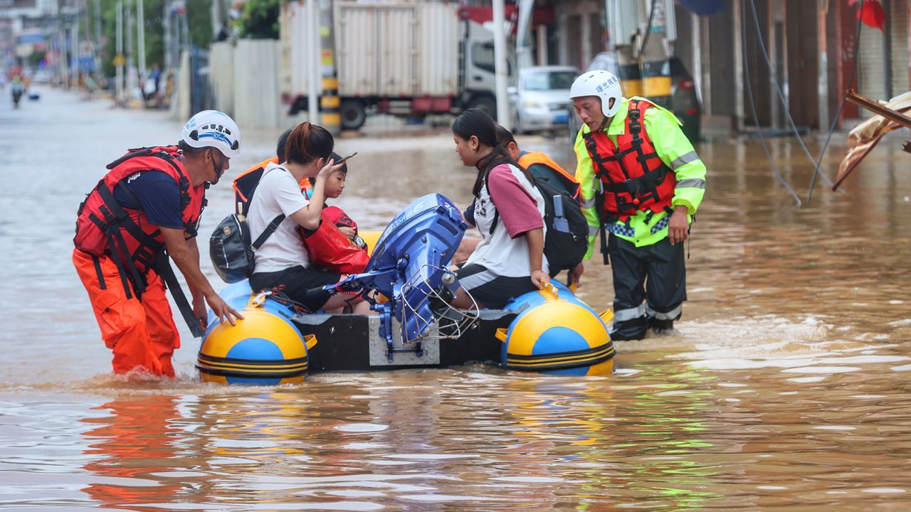 A civilian rescue team help flood-stranded people onto a rubber boat in Quanzhou in  southeast China's Fujian province on July 29, 2023. 