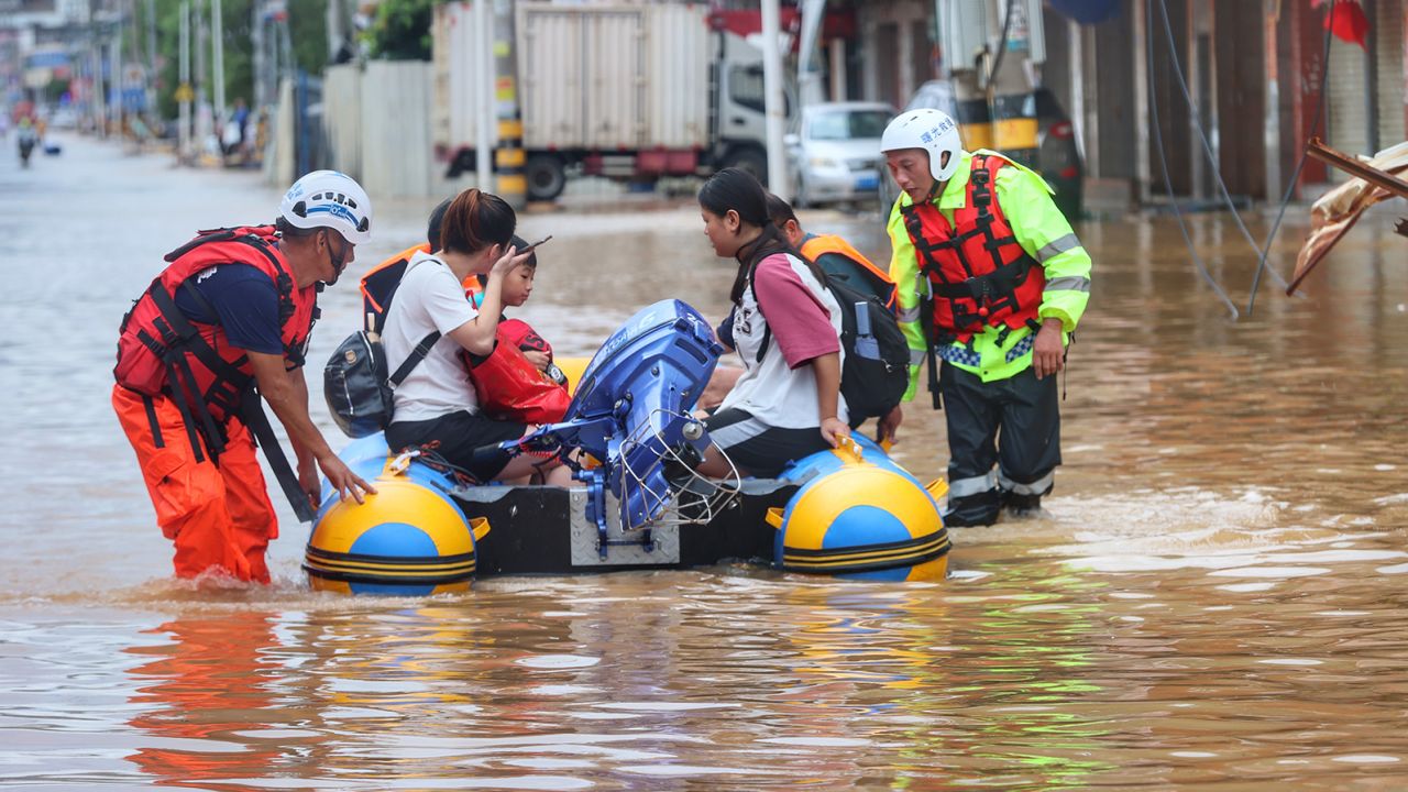 A civilian rescue team help flood-stranded people onto a rubber boat in Quanzhou in southeast China's Fujian province on July 29, 2023.