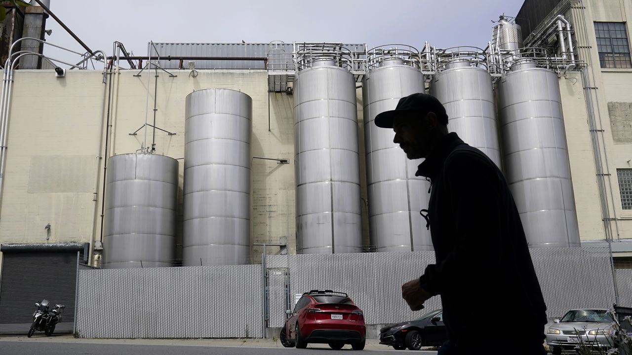 A person walks across the street from Anchor Brewing Co. in San Francisco.