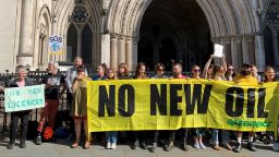Protestors gather outside the Royal Courts of Justice in London on July 25, 2023, ahead of a legal challenge from climate campaign groups over the government's opening of a new round of oil and gas extraction licensing in the North Sea. Photo by Tom Pilgrim/PA Images via Getty Images. 