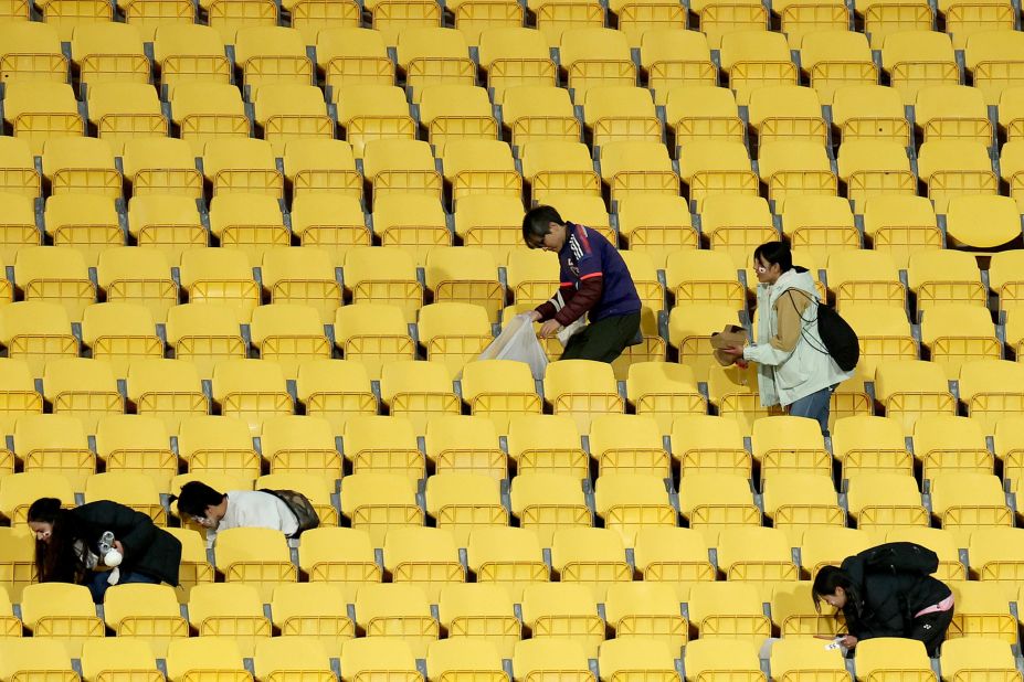 Fans of Japan help clean after the match in Wellington, New Zealand. Japan's fans have become known in recent years for their efforts to <a href=