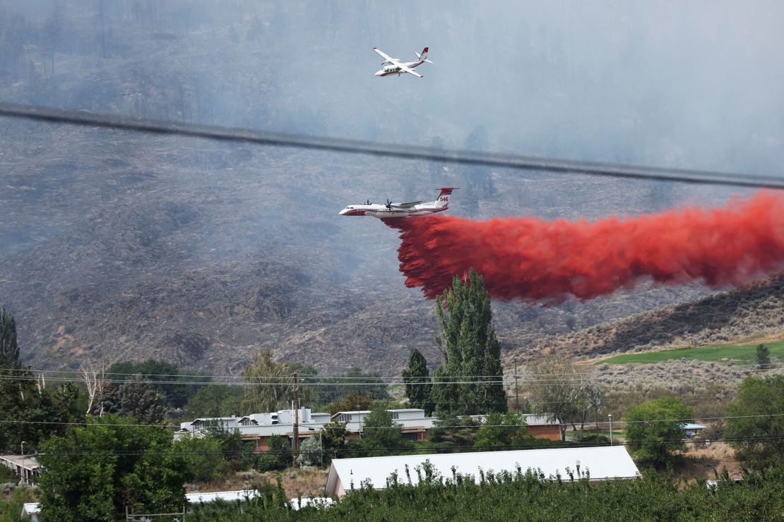 An air tanker drops fire retardant on the Eagle Bluff wildfire after it crossed the Canada-US border from the state of Washington and prompted evacuation orders in Osoyoos, British Columbia, Canada, July 30, 2023.