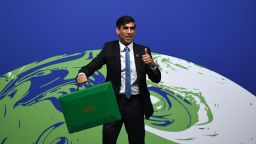 Канцлер на Великобритания на хазната Риши Сунак позира със зелено куфарче, подобно на червената бюджетна кутия, преди да открие Деня на финансите на срещата на високо равнище на ООН за климата COP26 в Глазгоу на 3 ноември 2021 г. - Сунак трябва да обяви плановете си да превърне Великобритания в първата в света финансова услуга с нулева нета център до 2050 г., каза Министерството на финансите. (Снимка от Daniel LEAL / AFP) (Снимка от DANIEL LEAL/AFP чрез Getty Images)