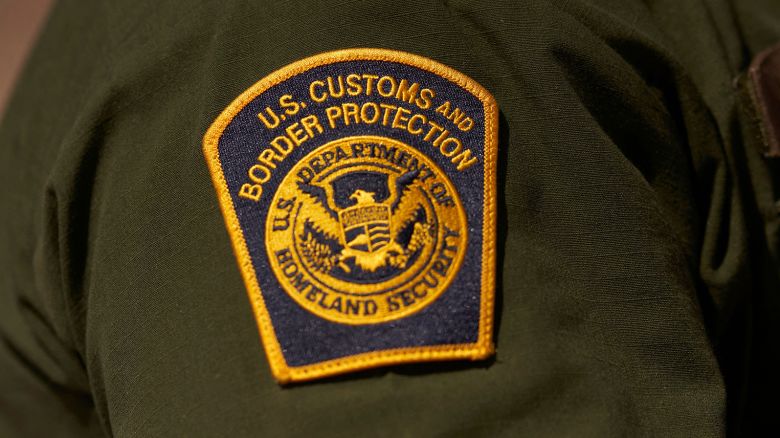 A US Customs and Border Protection patch is seen on the arm of an agent in the Jacumba mountains on October 6, 2022 in Imperial County, California. - In the fiscal year 2022 the number of migrant apprehensions exceeded 2 million, a new record in US Border Patrol history, but these apprehensions include many repeat offenders. (Photo by allison dinner / AFP) (Photo by ALLISON DINNER/AFP via Getty Images)