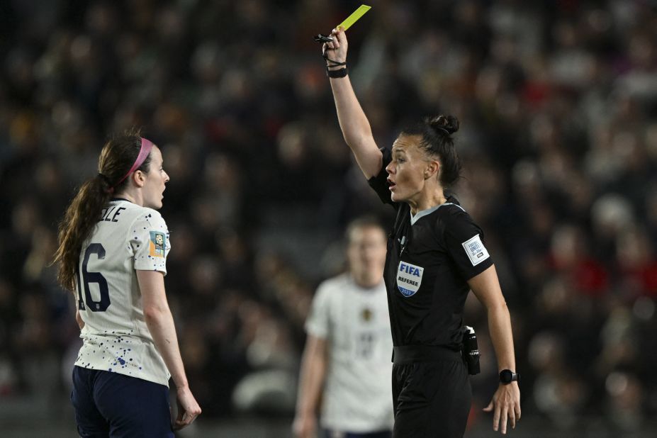 Referee Rebecca Welch shows a yellow card to US midfielder Rose Lavelle.