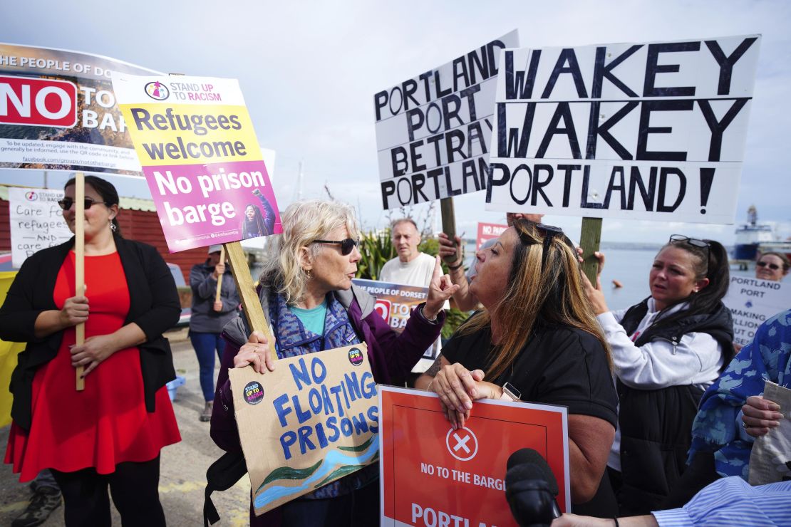 Rival protesters argue in Portland, Dorset, after the barge docked on July 18, 2023.