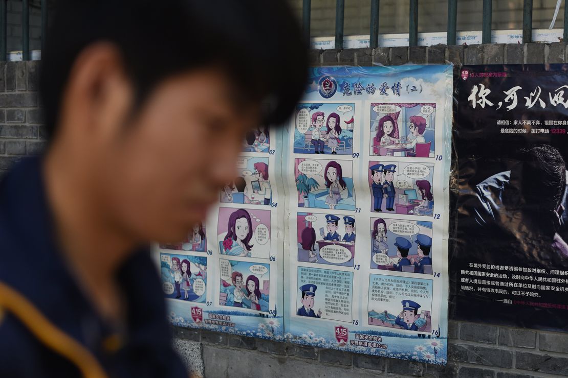 A man walks past a propaganda poster warning Chinese residents about foreign spies, in Beijing on May 23, 2017.