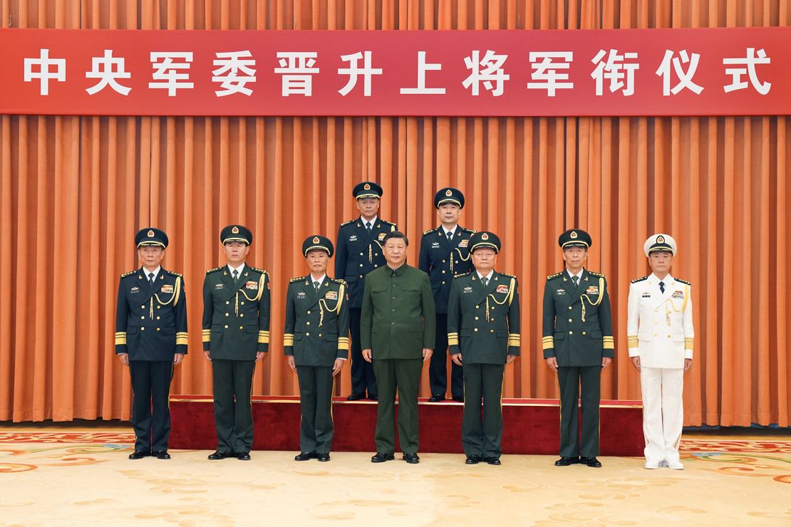 Chinese leader Xi Jinping, center, with new Rocket Force leadership Wang Houbin, back left, and Xu Xisheng, back right, after their promotion to the rank of general in Beijing on July 31, 2023. 