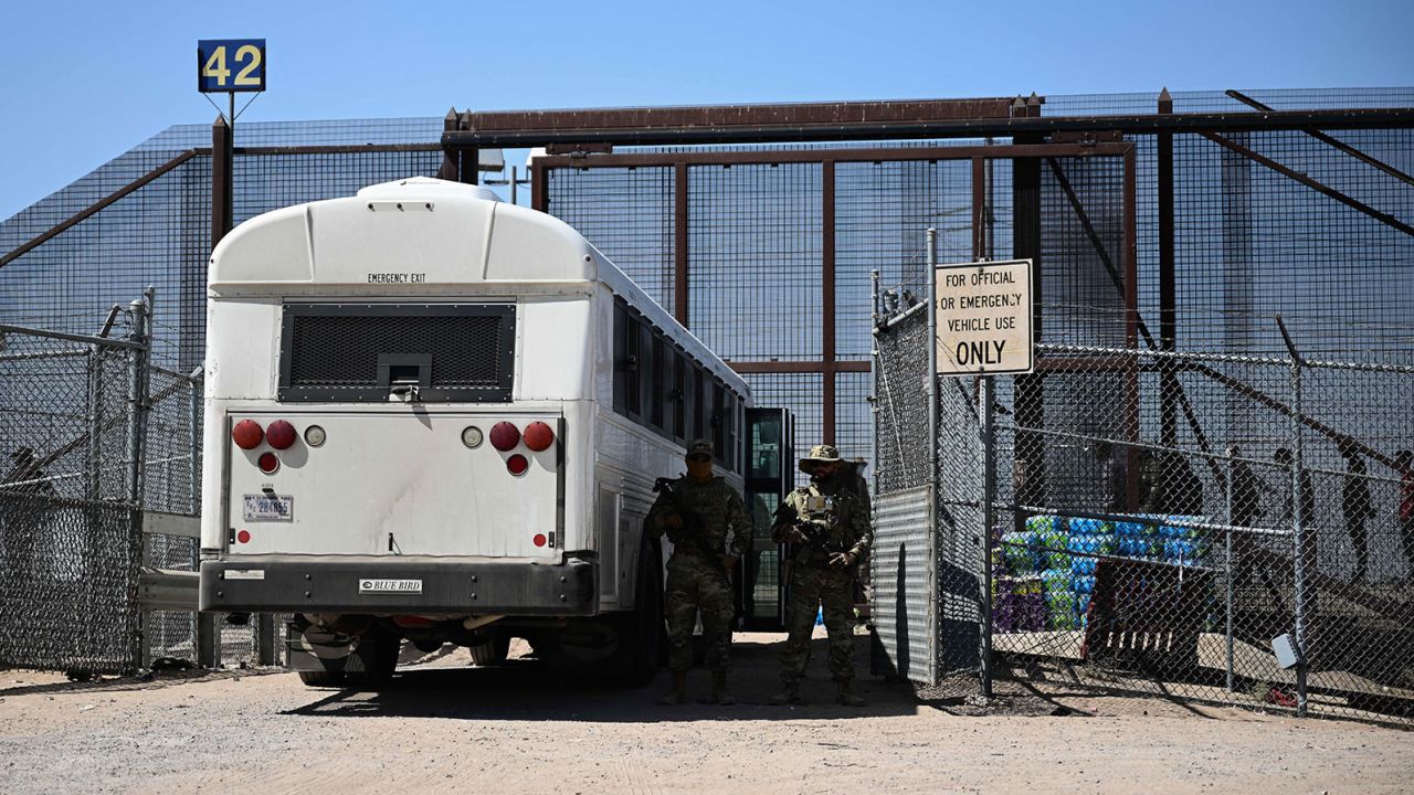 Texas Army National Guard look on as migrants board a bus after surrendering to US Customs and Border Protection (CBP) Border Patrol agents for immigration and asylum claim processing following the end of Title 42 on the US-Mexico border in El Paso, Texas on May 12, 2023. The US on May 11, 2023 officially ended its 40-month Covid-19 emergency, also discarding the Title 42 law, a tool that has been used to prevent millions of migrants from entering the country. (Photo by Patrick T. Fallon / AFP) (Photo by PATRICK T. FALLON/AFP via Getty Images)