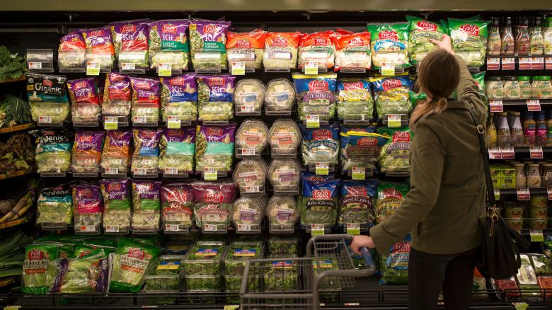 Sarah Moak grabs a bag of pre-packaged romaine lettuce hearts from a shelf in a Portland grocery store on April 20, 2018.