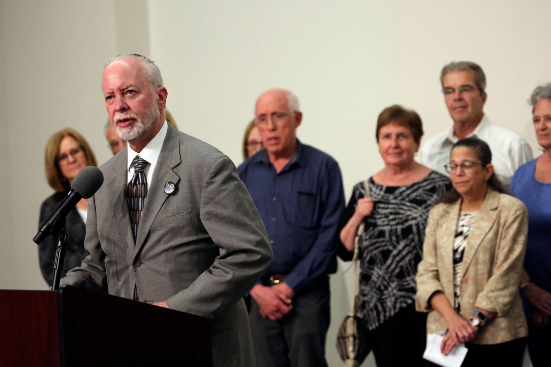 Rabbi Jeffrey Myers, surrounded by victims and families of victims, speaks to the media on Wednesday.