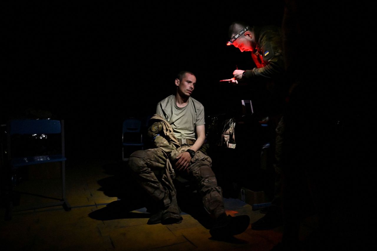 A medic speaks with an injured Ukrainian serviceman inside a frontline medical stabilization point in Ukraine on Thursday, July 27.
