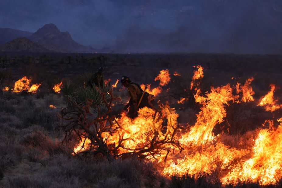 Firefighters battle flames from the York Fire in the Mojave National Preserve on Sunday, July 30. The fire has <a href=