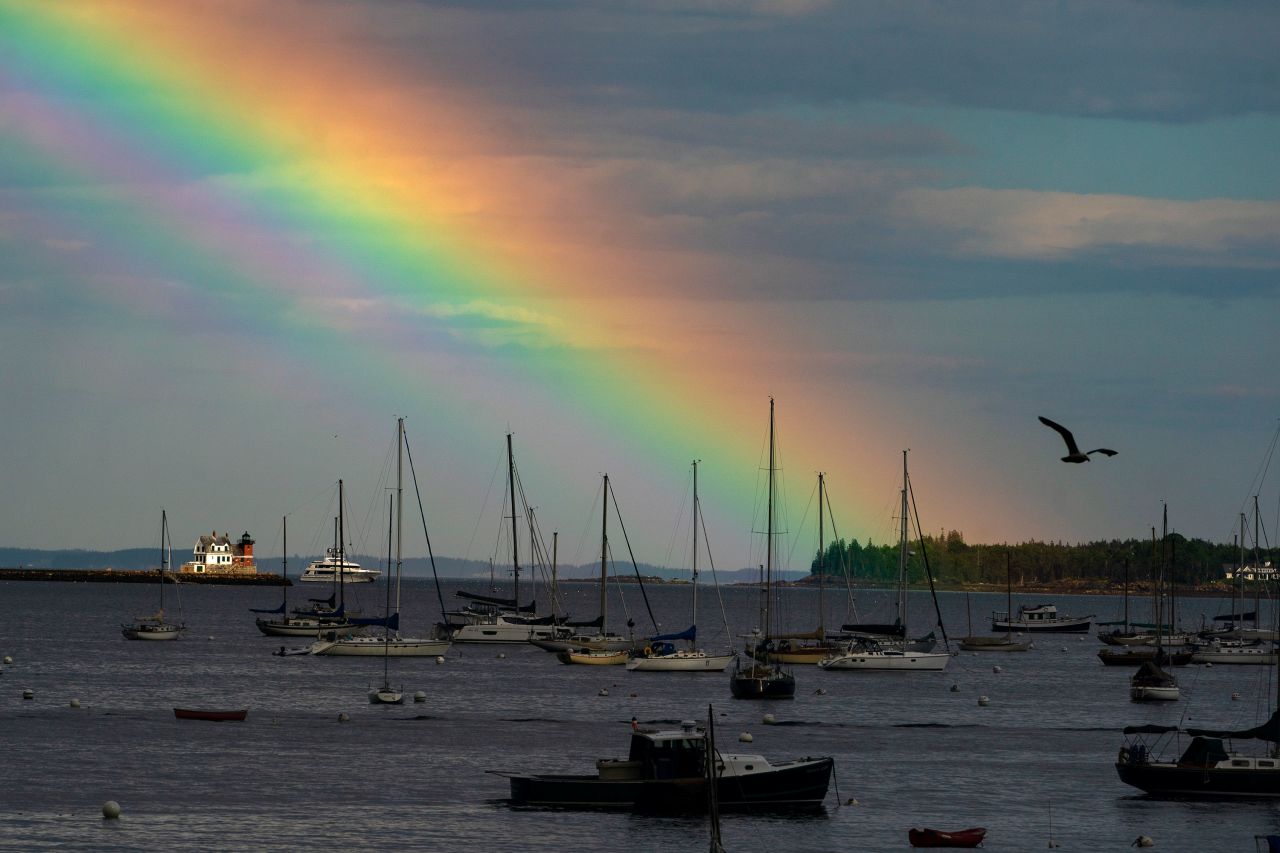 A rainbow colors the sky beyond the Rockland Harbor Breakwater Lighthouse following a brief rainstorm in Rockland, Maine, on Tuesday, August 1. 