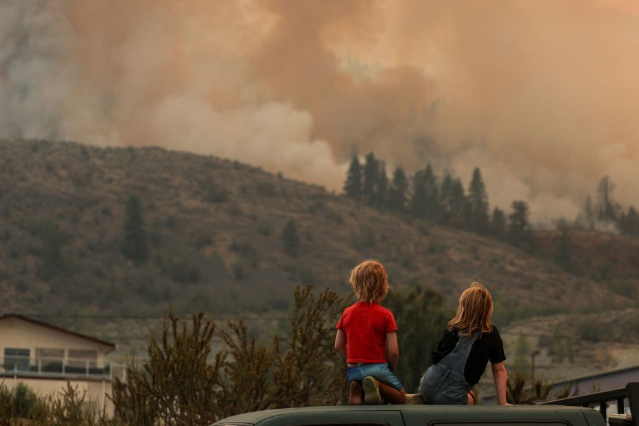 Locals watch firefighting efforts amid heavy smoke from the Eagle Bluff Fire after it <a href=