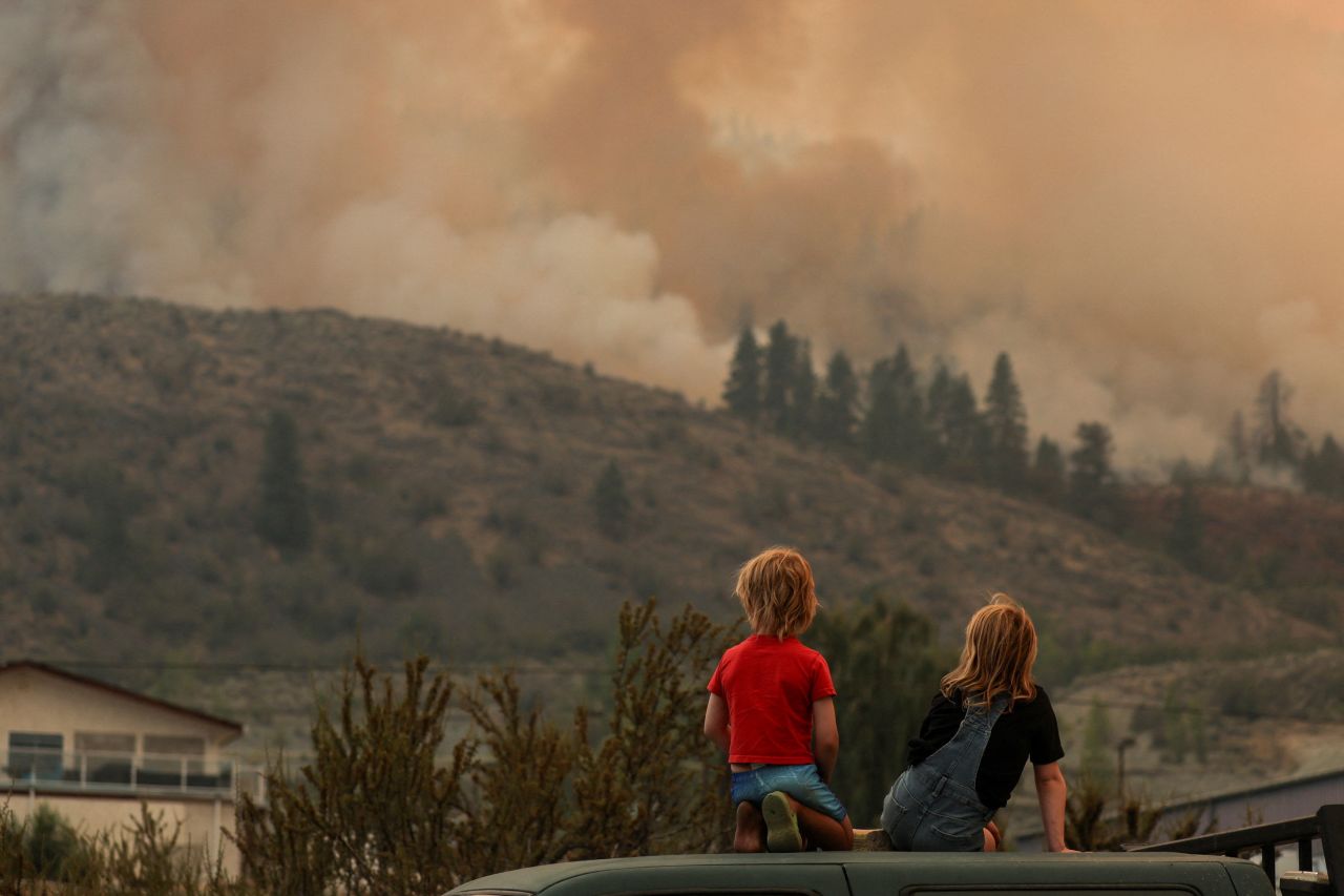 Locals watch firefighting efforts amid heavy smoke from the Eagle Bluff Fire after it <a href="https://www.cnn.com/2023/07/31/weather/bc-wildfires-canada-washington-climate/index.html" target="_blank">crossed the US-Canada border</a> from Washington state into Osoyoos, British Columbia, Canada, on Sunday July 30.
