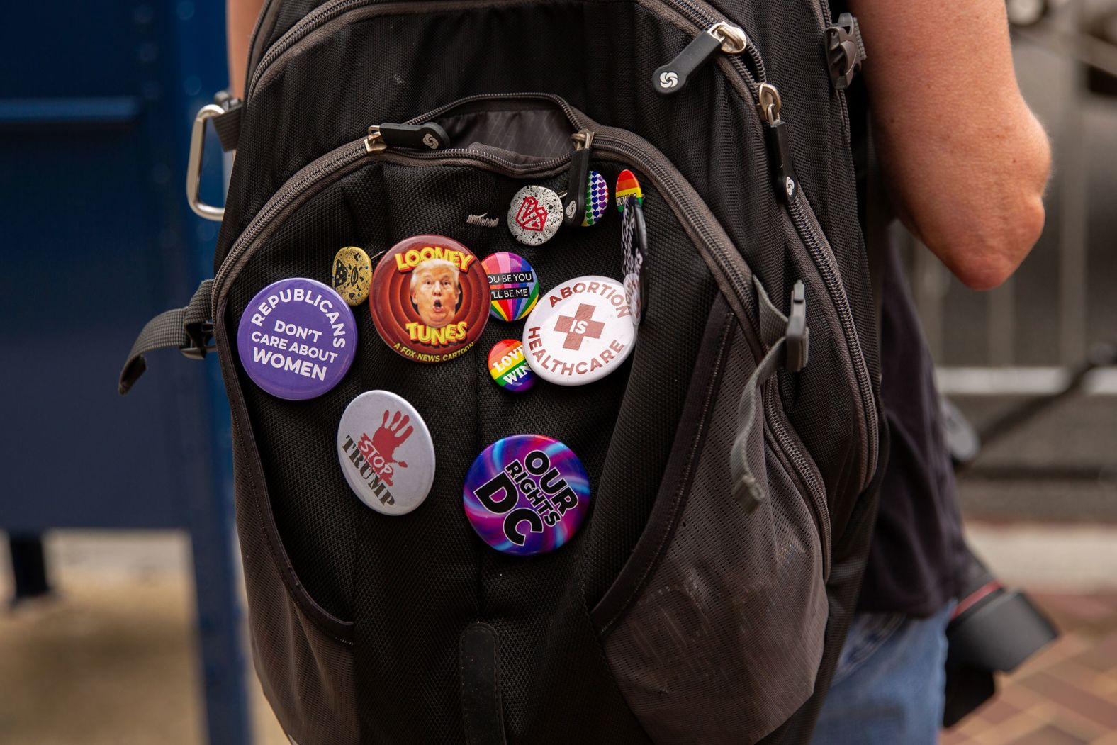 Buttons adorn a person's backpack outside the courthouse.