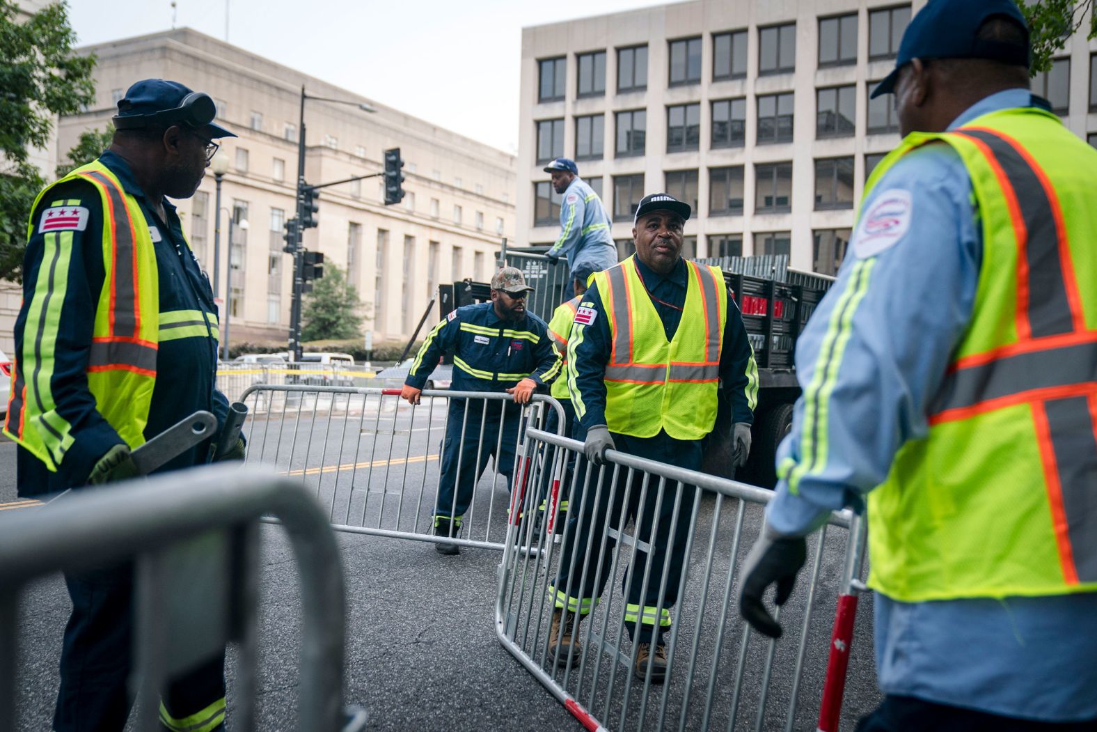 Workers install security fencing along the street outside the courthouse Thursday.